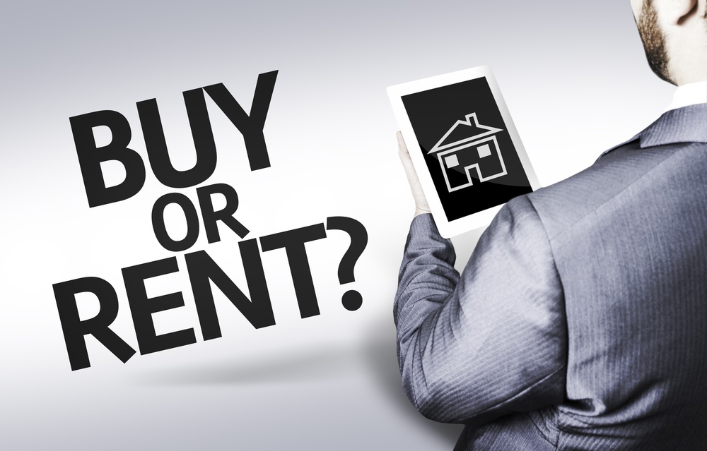 Man holding a tablet with a house on it with text that says buy or rent?