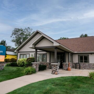 Traverse City Garfield Ave Branch office. Green lawn. Huge Honor Bank sign in the front of their building.