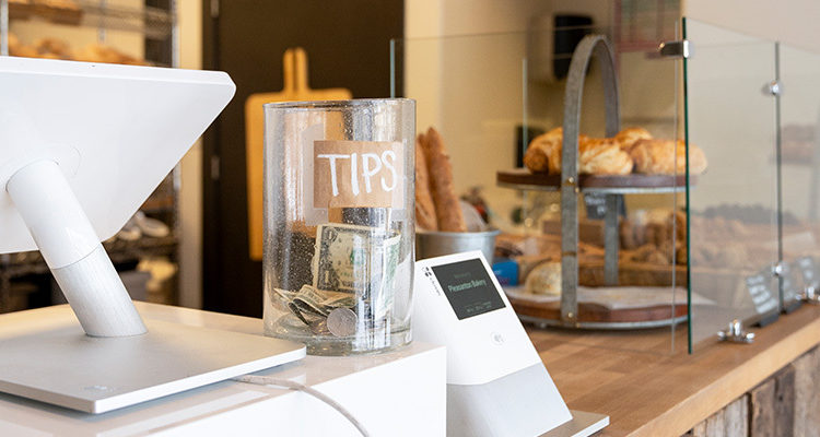 Tips jar at a bakery on the counter.