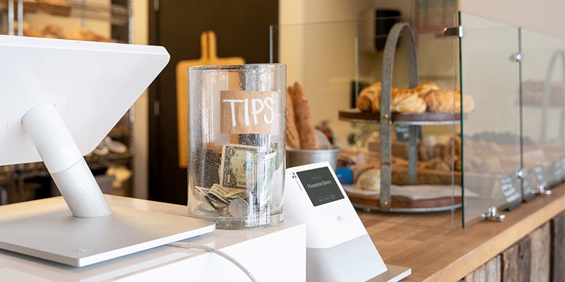 Tips jar at a bakery on the counter.