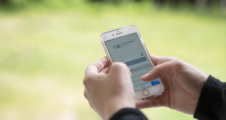 Person mobile banking with Honor Bank on their phone