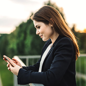 A young lady checking her Honor Bank account on her phone.