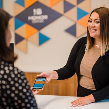 Honor Bank employee showing how to utilize online banking to user