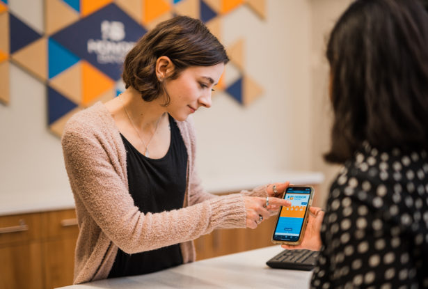 Honor Bank Employee explaining client how to use online banking app