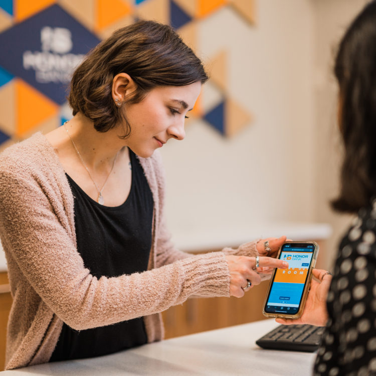 Honor Bank Employee explaining client how to use online banking app