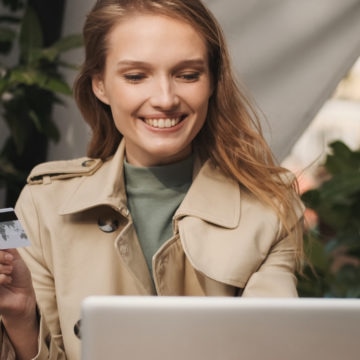 Young woman with credit card checking her personal checking account on laptop