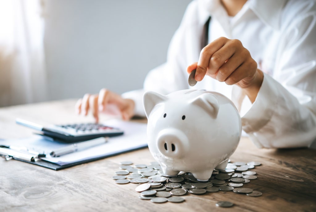 Hand holding coin with pig piggy bank. Saving and financial account