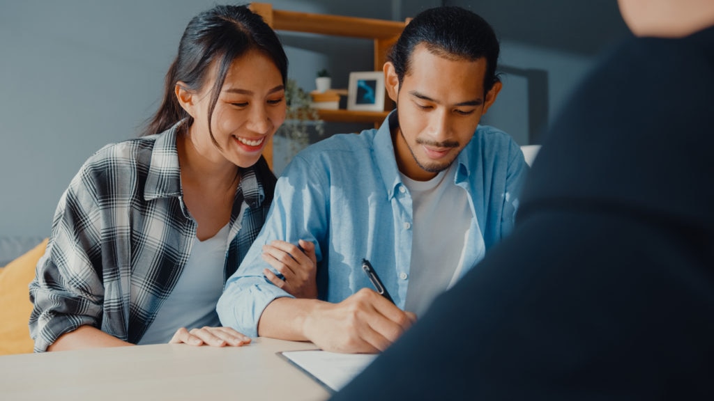 couple signing bank loan agreement