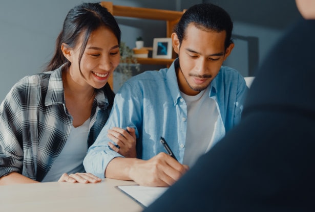 couple signing bank loan agreement