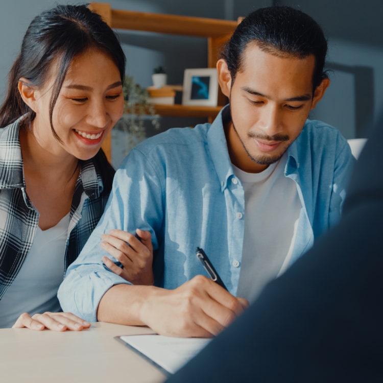 couple signing bank loan agreement