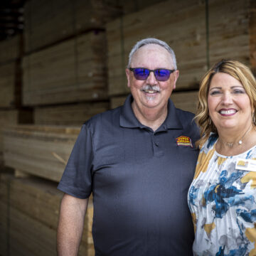 Honor - Onekama Hardware - A man and a woman standing in front of a display of lumber
